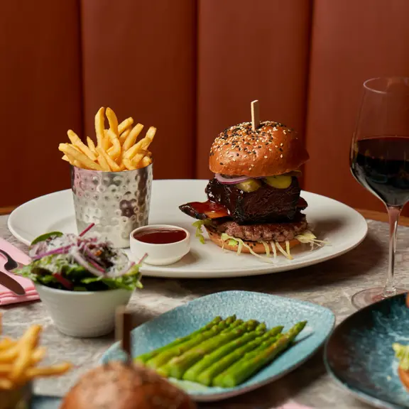 burgers and chips with a side of asparagus