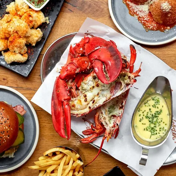 Burger and lobster food on a laid table