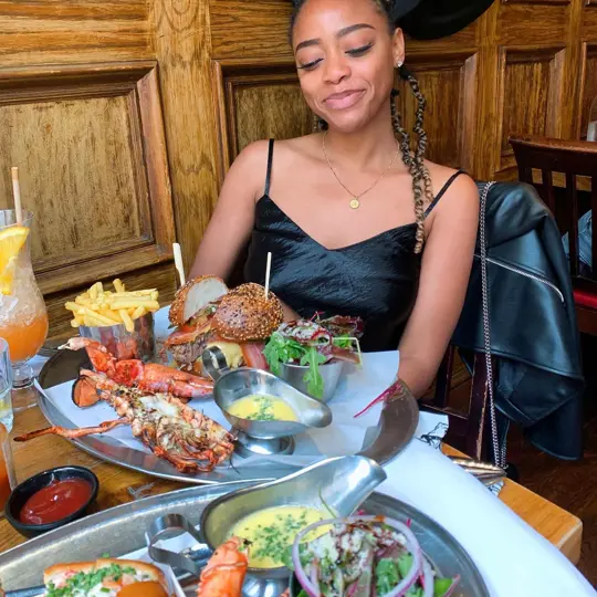 Girl smiling with a combo plate from Burger and Lobster
